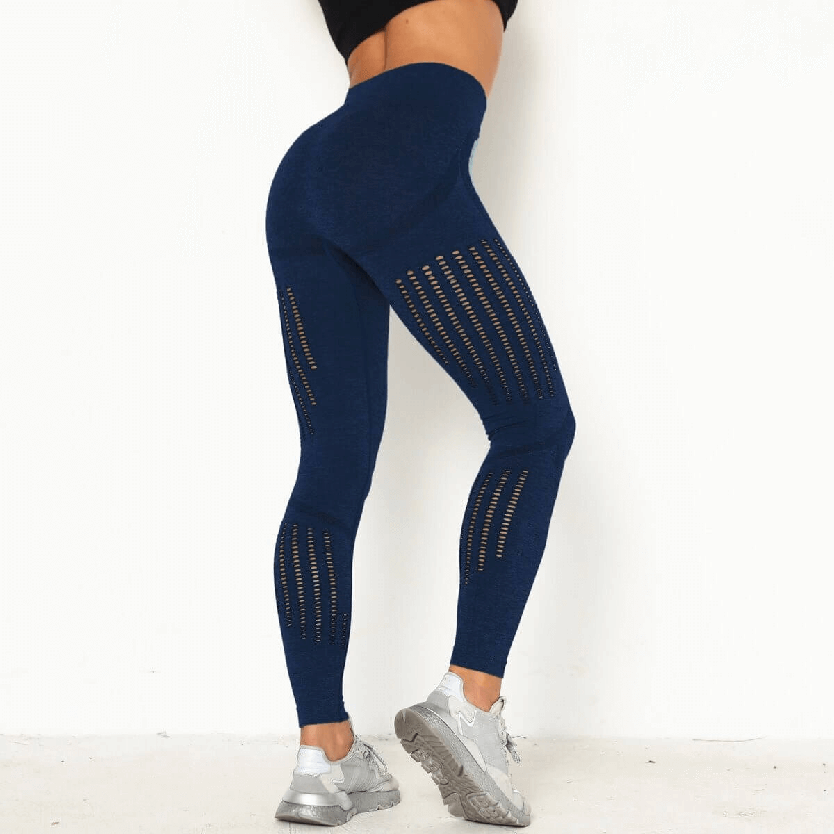 Woman wearing high-waist seamless blue leggings with perforated design, showcasing a flattering fit and comfort.